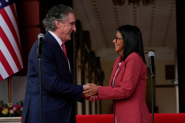 Venezuela's acting President Delcy Rodriguez, right, and U.S. Interior Secretary Doug Burgum shake hands after a meeting at Miraflores presidential palace in Caracas, Venezuela, Wednesday, March 4, 2026. (AP Photo/Ariana Cubillos)